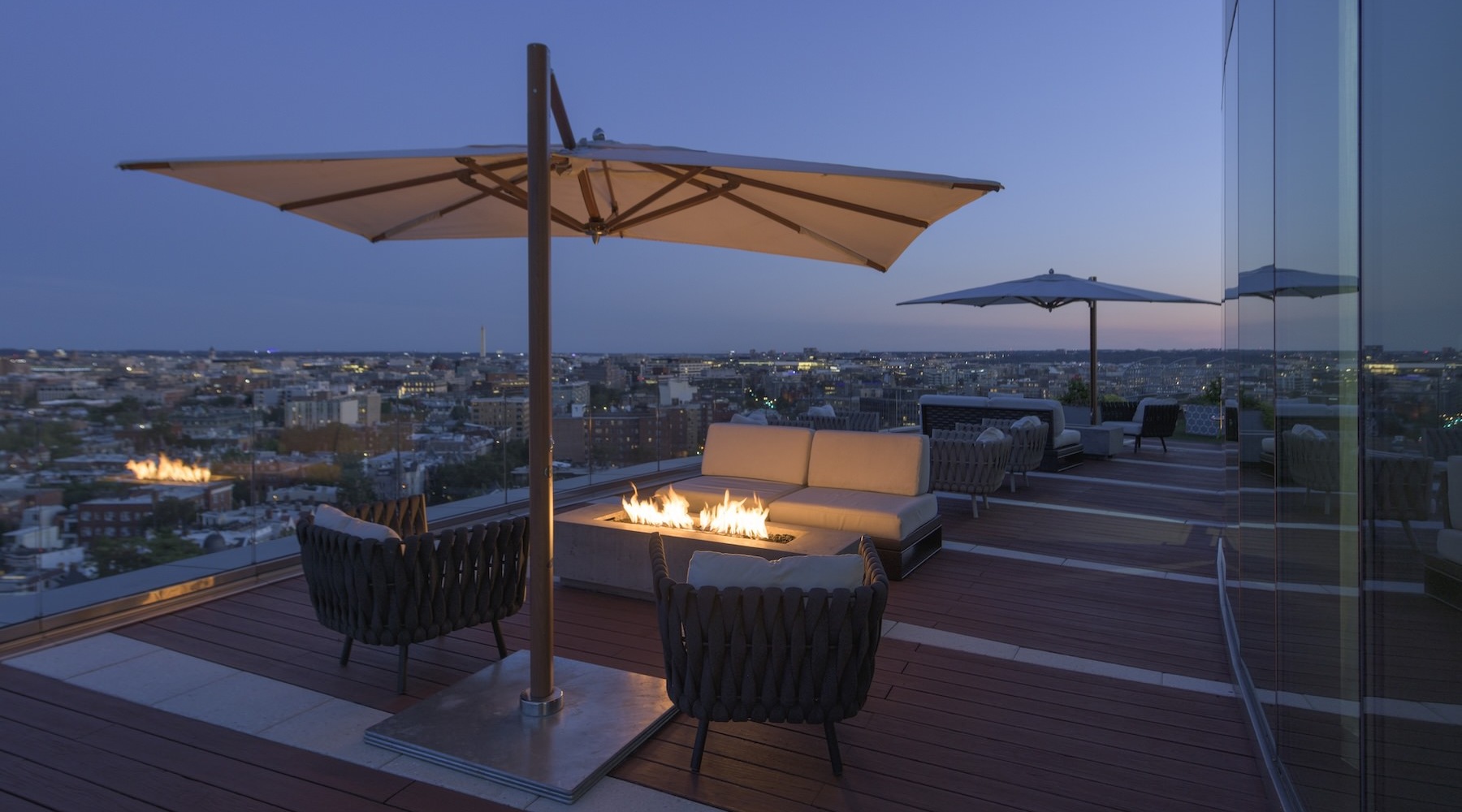a fire pit with couches and an umbrella