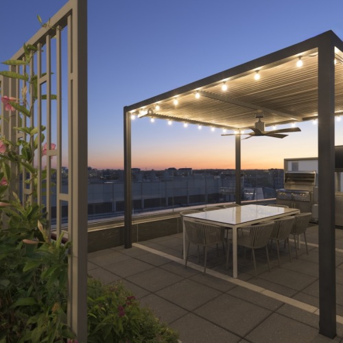 a rooftop outdoor lounge area with a table and chairs