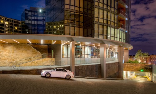 a car driving up a road next to a building